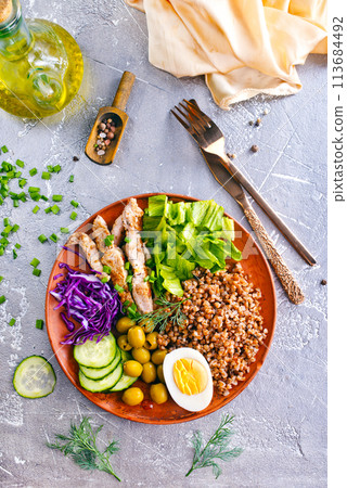 Boiled buckwheat or porridge with chicken for breakfast, cooked salted eggs, vegetables and fresh greens Boiled buckwheat or porridge with chicken for breakfast, cooked salted eggs, vegetables and fresh greens 113684492