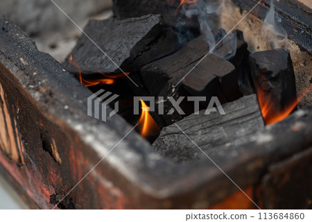 Burning charcoal 113684860