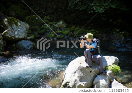 Photographer taking pictures of the landscape Photographer taking pictures of the landscape 113685425