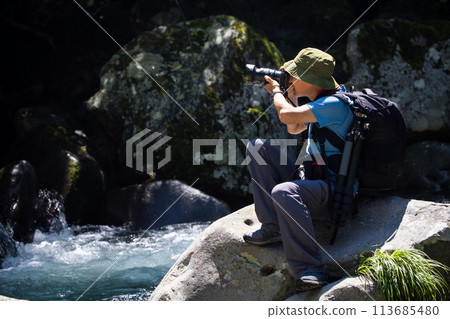 Photographer taking pictures of the landscape Photographer taking pictures of the landscape 113685480