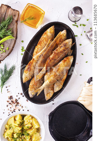 fried fish in pan on a table fried fish in pan on a table 113685670