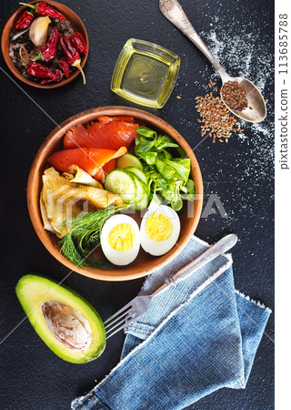 Delicious healthy brunch - boiled egg, smoked salmon, green salad and savory pancakes on a dark background, top view Delicious healthy brunch - boiled egg, smoked salmon, green salad and savory pancakes on a dark background, top view 113685788