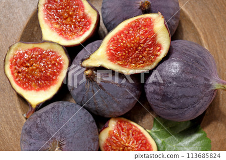Fresh ripe figs in a wooden bowl on a light background 113685824