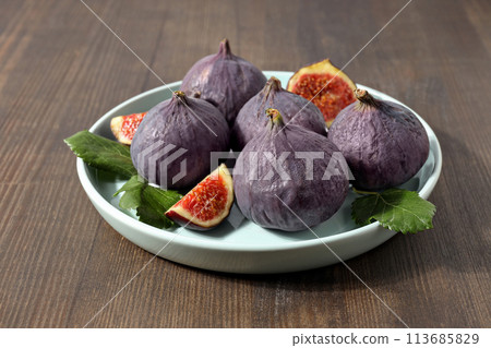 Fresh ripe figs in a bowl on a wooden background 113685829