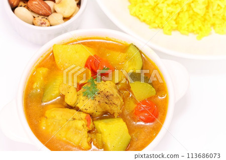 Nepalese soup curry with zucchini, chicken, potatoes and yellow rice on a light background 113686073