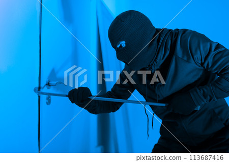 Burglar with a crowbar trying to break in Burglar with a crowbar trying to break in 113687416