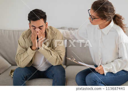 Upset man with hand on face during therapy Upset man with hand on face during therapy 113687441