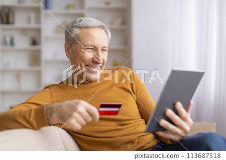 Mature man shopping online with tablet and card 113687518