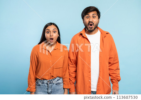 Couple showing surprise and excitement on blue 113687530