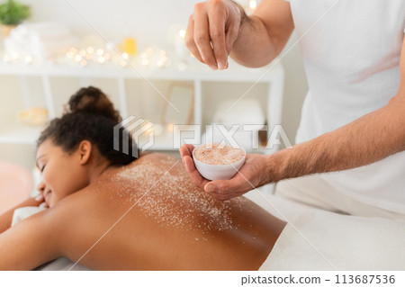 Applying exfoliating scrub during spa treatment at spa Applying exfoliating scrub during spa treatment at spa 113687536