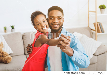 Handsome father and cute daughter dancing at home 113687550