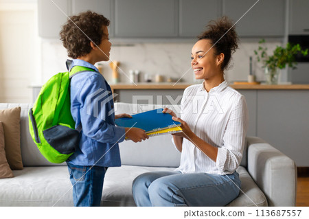 Son taking school items from mother 113687557