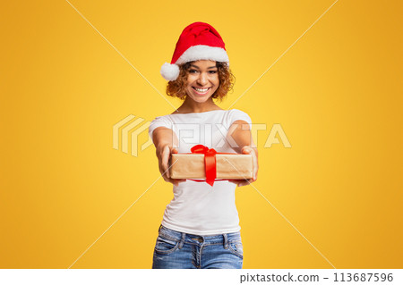 Beautiful african-american girl in Santa hat holding presents 113687596