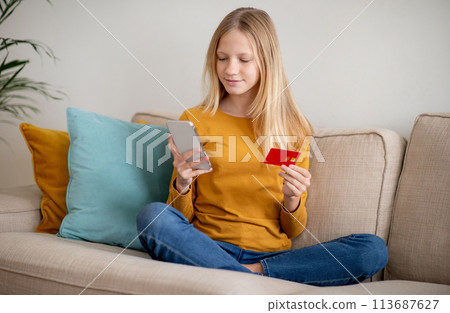 Teen Girl Shopping Online With Credit Card and Smartphone Teen Girl Shopping Online With Credit Card and Smartphone 113687627