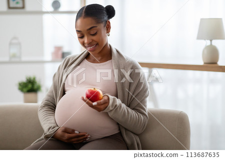 Positive healthy expecting african american woman eating apple 113687635