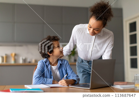 Mom helping son with homework at desk 113687647