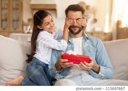 Daughter covering father's eyes, gift in her hand Daughter covering father's eyes, gift in her hand 113687667