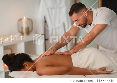 Massage therapist working on African American lady 113687710