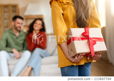 Child surprising parents with a gift, focus on present 113687784