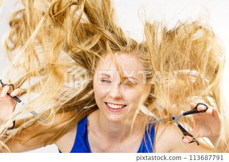 Young woman with scissors for haircutting Young woman with scissors for haircutting 113687791