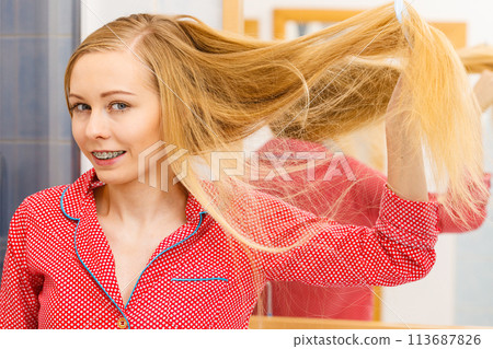Woman combing her long hair in bathroom 113687826