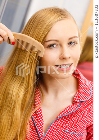 Woman combing her long hair in bathroom Woman combing her long hair in bathroom 113687832