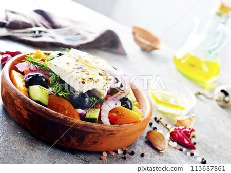 Greek salad of fresh cucumber, tomato, sweet pepper, lettuce, red onion, feta cheese and olives with olive oil. Healthy food, top view 113687861