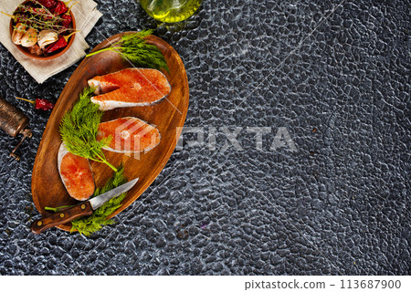 fresh salmon steak raw fish prepared for cooking. Top view on black slate table. fresh salmon steak raw fish prepared for cooking. Top view on black slate table. 113687900