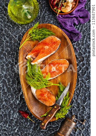 fresh salmon steak raw fish prepared for cooking. Top view on black slate table. fresh salmon steak raw fish prepared for cooking. Top view on black slate table. 113687901