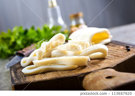 Boiled calamari squid rings on wooden board, cooked squid on cutting rings on board. 113687920