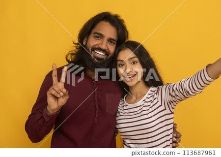 Selfie of cheerful couple with peace sign 113687961