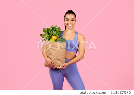 Woman holding bag of fresh groceries 113687970