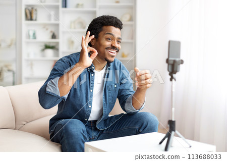 Smiling Black Man Making OK Gesture During a Video Call at Home Smiling Black Man Making OK Gesture During a Video Call at Home 113688033