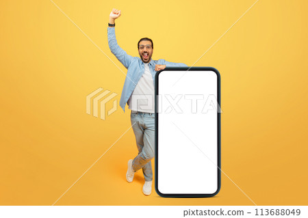 Excited man with oversized smartphone 113688049