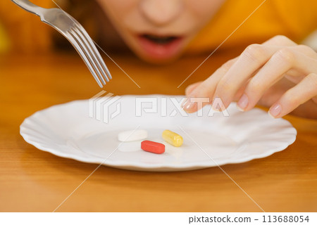 Shocked woman having pills on plate 113688054