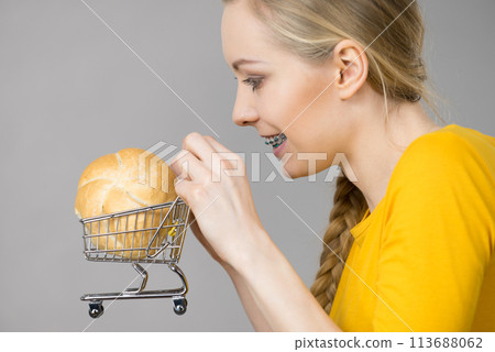Woman holding shopping cart with bread 113688062