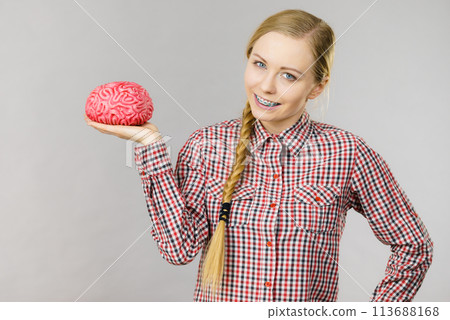 Woman thinking and holding fake brain Woman thinking and holding fake brain 113688168