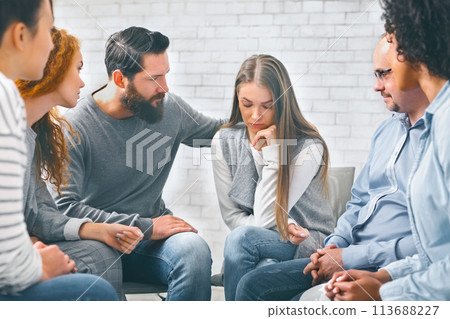Concerned patients comforting depressed woman in rehab group Concerned patients comforting depressed woman in rehab group 113688227