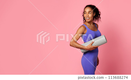 Woman smiling and holding rolled yoga mat Woman smiling and holding rolled yoga mat 113688274