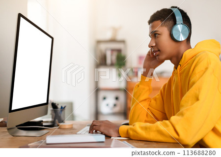 Man in yellow hoodie working at computer Man in yellow hoodie working at computer 113688280