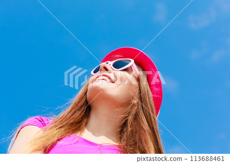 Woman wearing heart shaped sunglasses and hat 113688461