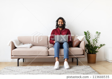 Man working on laptop with a smile Man working on laptop with a smile 113688535