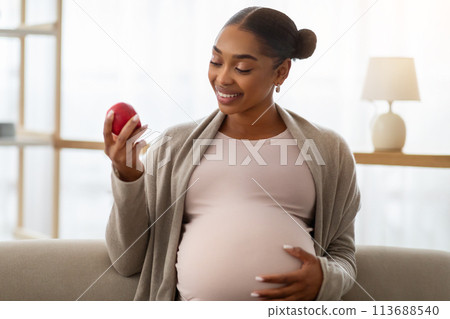 Portrait of pregnant african american woman holding red apple Portrait of pregnant african american woman holding red apple 113688540