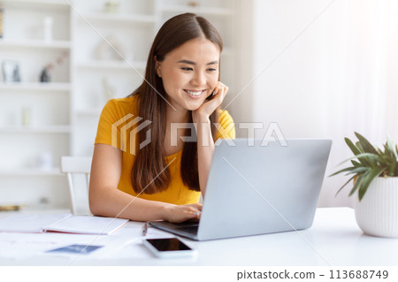 Thoughtful woman with laptop at home office 113688749