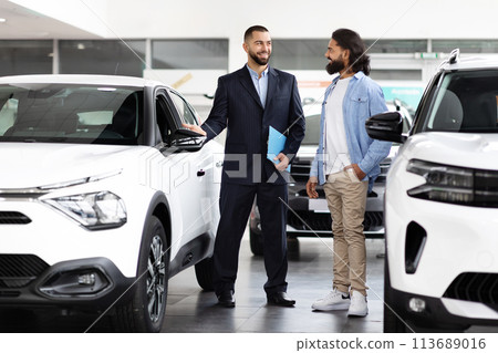 Salesman discussing cars with customer Salesman discussing cars with customer 113689016