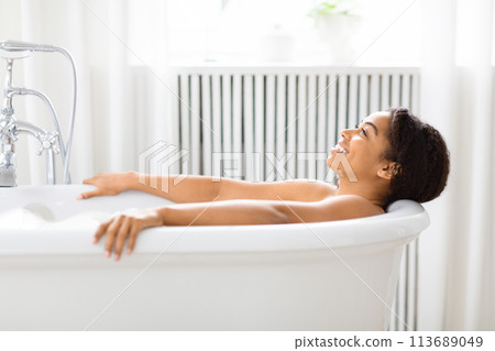 Woman enjoys serene moment in tub at home Woman enjoys serene moment in tub at home 113689049