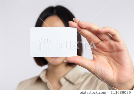 Asian businesswoman holding business card isolated on white background Asian businesswoman holding business card isolated on white background 113689059