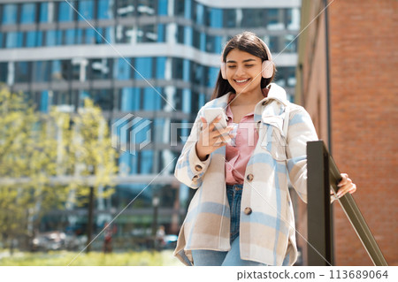 University student with jacket texting on phone University student with jacket texting on phone 113689064