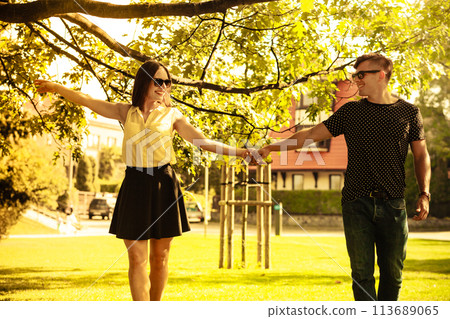 Couple holding hands in park. Couple holding hands in park. 113689065