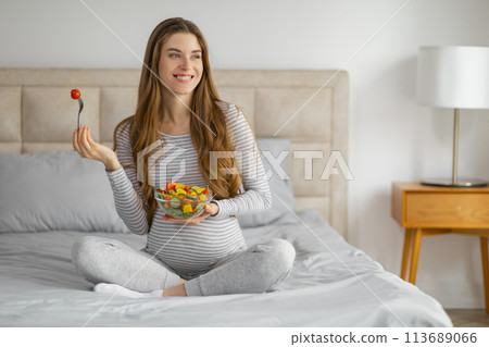 Pregnant woman enjoying a bowl of fruit salad Pregnant woman enjoying a bowl of fruit salad 113689066